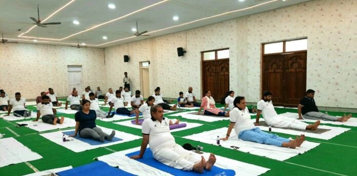 योग दिवस पर आयोजित शिविर में योगाभ्यास करते डीआरएम व रेल कर्मी।
