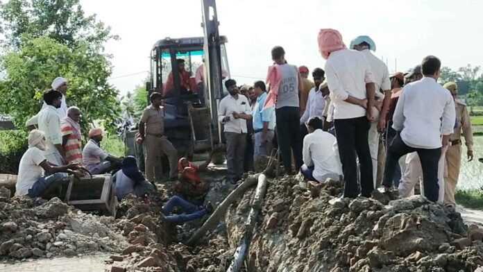 चंदौली कलेक्ट्रेट के पास बिजली के केबल बिछाने का विरोध करता किसान परिवार।