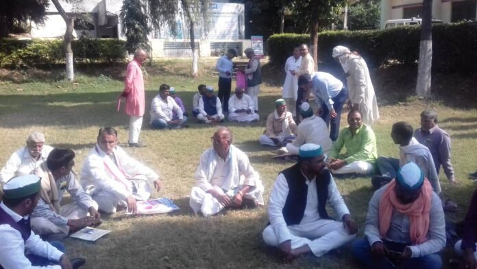 कृषि विज्ञान केंद्र परिसर में धरने पर बैठे किसान।