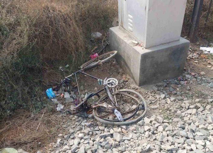 ट्रेन से टकराने के बाद रेलवे ट्रैक किनारे पड़ी क्षतिग्रस्त साइकिल।