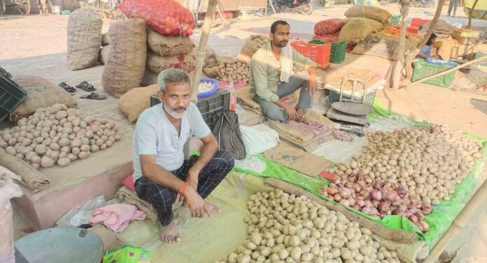 Chandauli मुख्यालय पर ग्राहकों के इंतज़ार में बैठे आलू प्याज के दुकानदार।