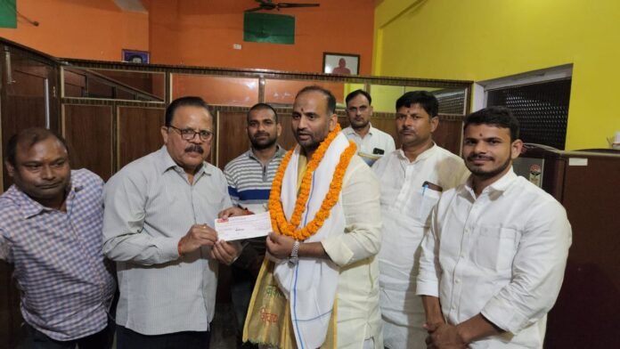 बाबा कीनाराम मठ के नाम काटे गए चेक को प्रदान करते मनोज सिंह डब्लू।