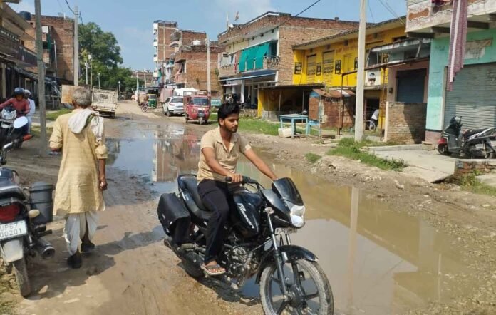 चहनियां कस्बा में क्षतिग्रस्त कीचड़युक्त मार्ग पर आते जाते लोग।