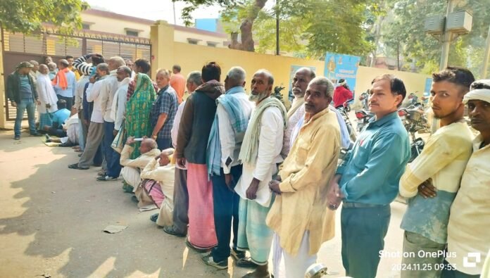 गेहूं के बीज के लिए Shahabganj राजकीय बीज गोदाम पर कतारबद्ध किसान।