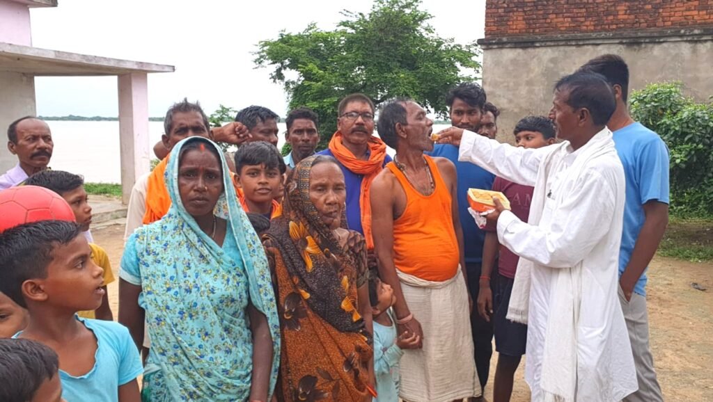 नरौली में मछुआरा समाज के लोगों का मुंह मीठा कराते महंगू राम।