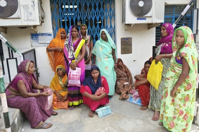 शहाबगंज में एसबीआई बैंक शाखा के बाहर बैठी महिलाएं।